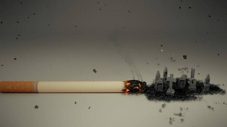 A burning cigarette on a grey surface.