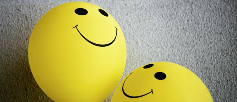 Colorful balloons against a wall.